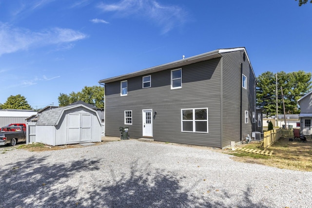 back of property featuring cooling unit and a storage unit