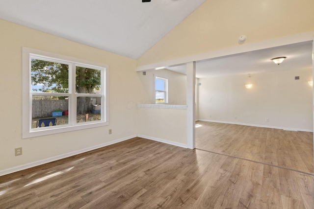 spare room with hardwood / wood-style flooring and lofted ceiling