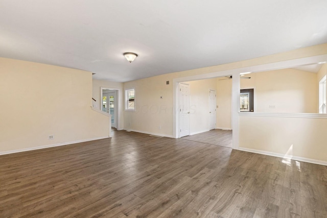 empty room with ceiling fan and dark wood-type flooring