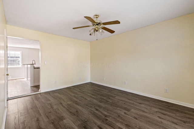 spare room featuring ceiling fan and dark hardwood / wood-style flooring