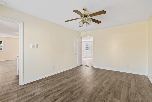 unfurnished room with ceiling fan and dark hardwood / wood-style flooring