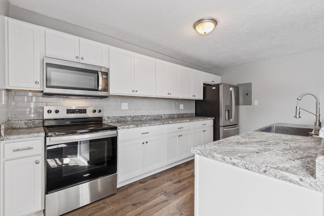 kitchen featuring white cabinetry, stainless steel appliances, decorative backsplash, dark hardwood / wood-style floors, and sink