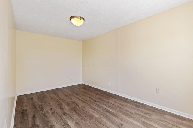 empty room with a textured ceiling and wood-type flooring