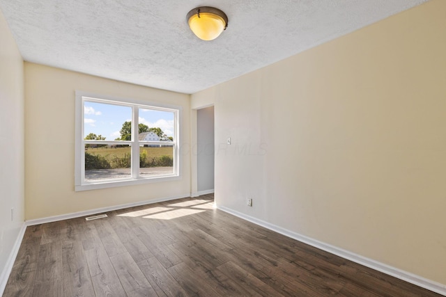 spare room featuring a textured ceiling and hardwood / wood-style floors