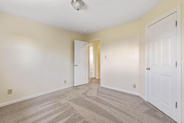 unfurnished room featuring light carpet