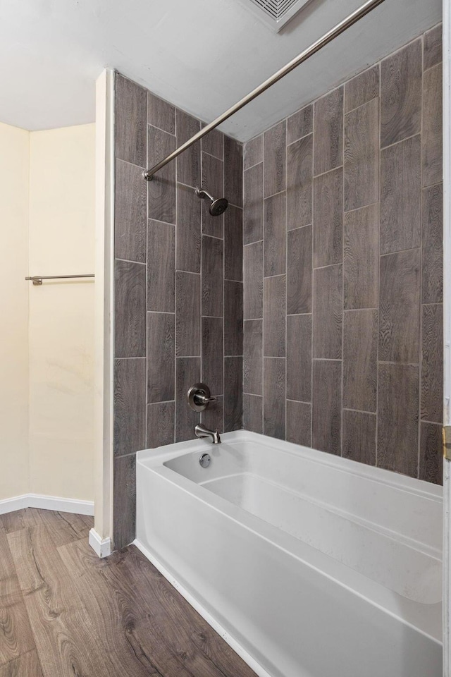 bathroom featuring hardwood / wood-style flooring and tiled shower / bath combo