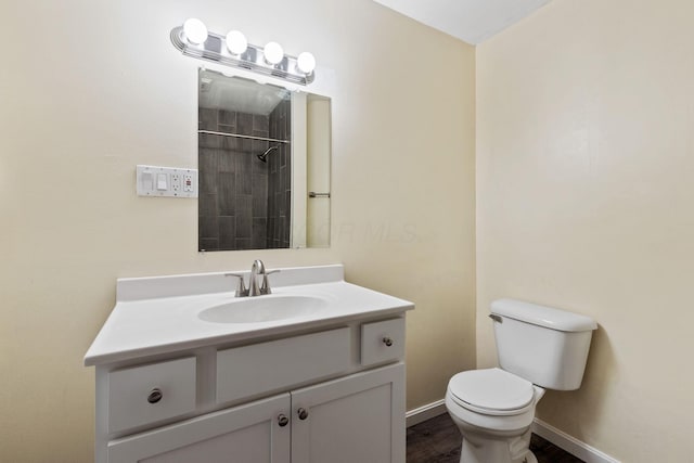 bathroom with a shower, hardwood / wood-style floors, toilet, and vanity