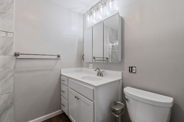 bathroom featuring toilet, vanity, and hardwood / wood-style floors