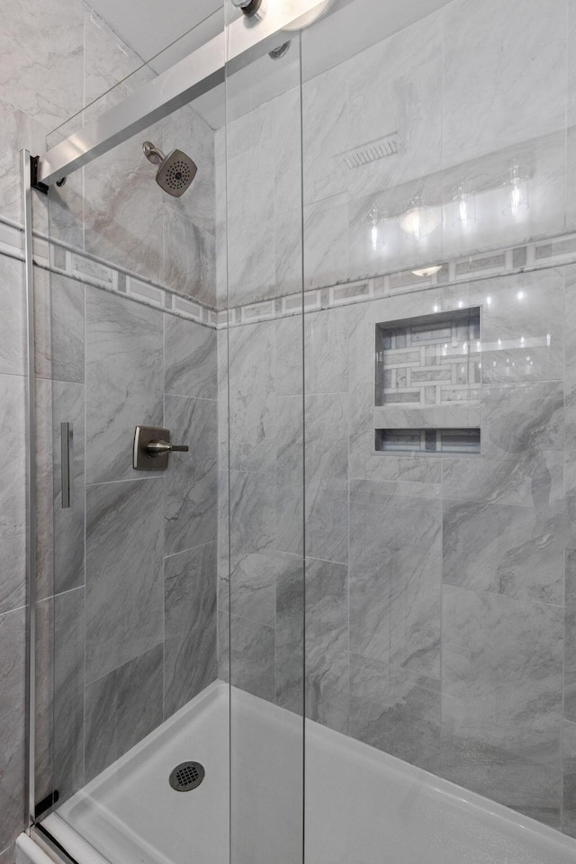 bathroom featuring a shower with door