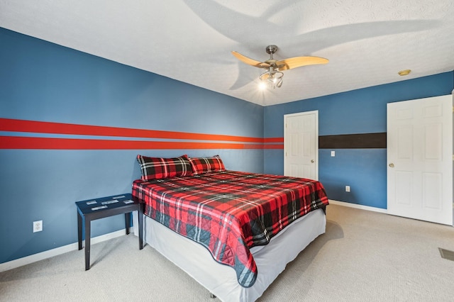 bedroom with carpet floors, baseboards, and a textured ceiling