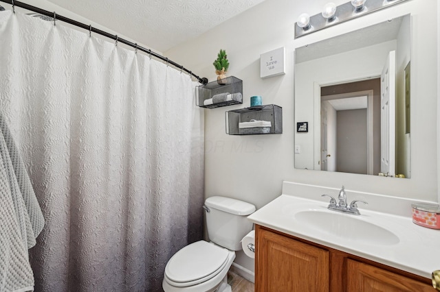 bathroom featuring a textured ceiling, vanity, and toilet