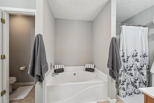 full bath with toilet, tile patterned floors, a garden tub, curtained shower, and a textured ceiling