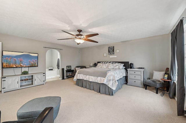 bedroom with arched walkways, ceiling fan, a textured ceiling, and carpet flooring