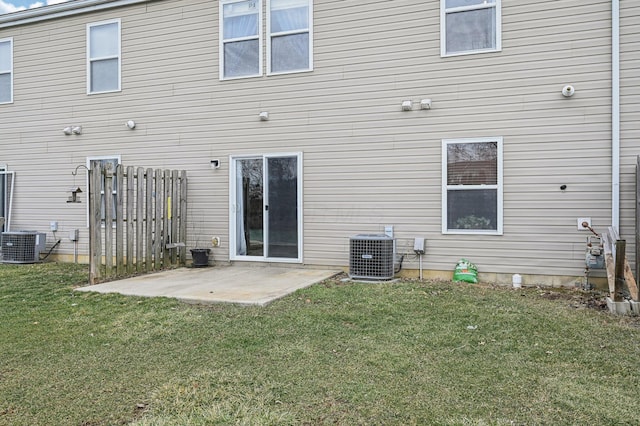 rear view of house featuring a patio area, a lawn, and central air condition unit