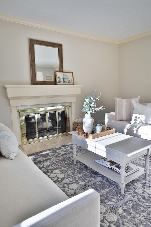 living room featuring crown molding and a tile fireplace