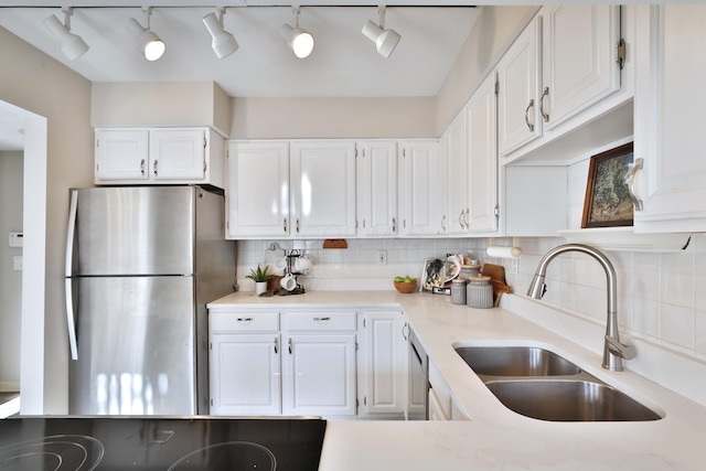 kitchen with tasteful backsplash, sink, white cabinets, and appliances with stainless steel finishes