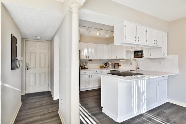 kitchen featuring white cabinetry, dark wood-type flooring, decorative backsplash, and kitchen peninsula