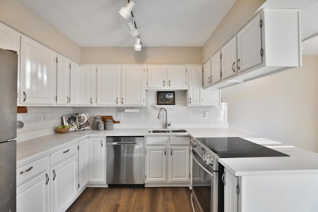 kitchen featuring sink, stainless steel appliances, track lighting, white cabinets, and dark hardwood / wood-style flooring