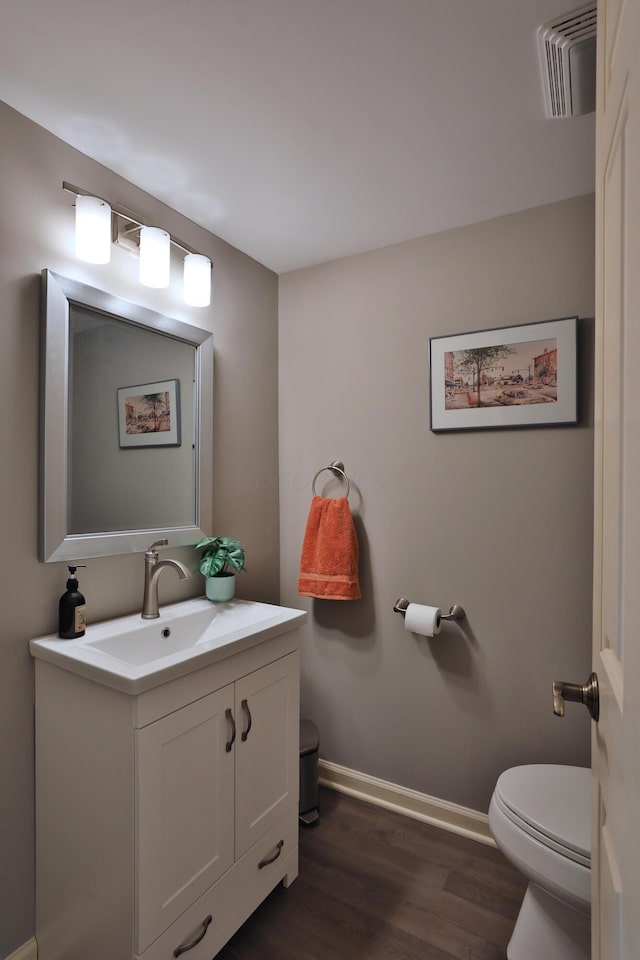 bathroom with vanity, toilet, and wood-type flooring