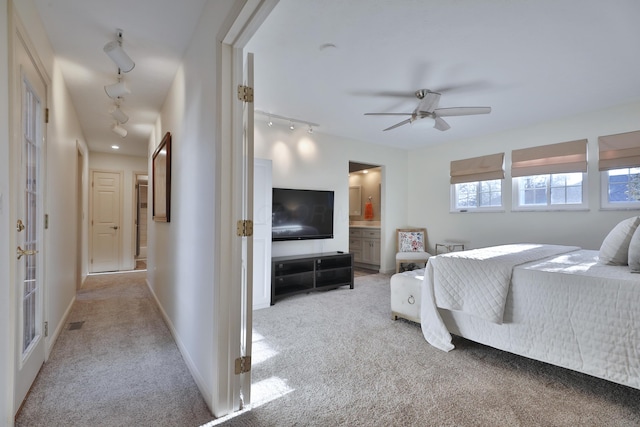 carpeted bedroom with ensuite bathroom and ceiling fan