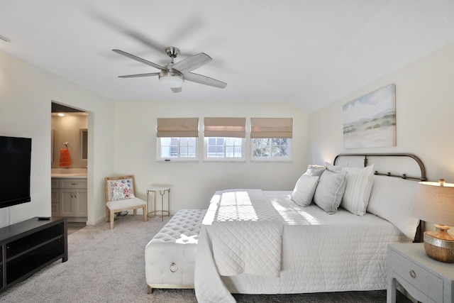 bedroom featuring ceiling fan, ensuite bathroom, vaulted ceiling, and light carpet