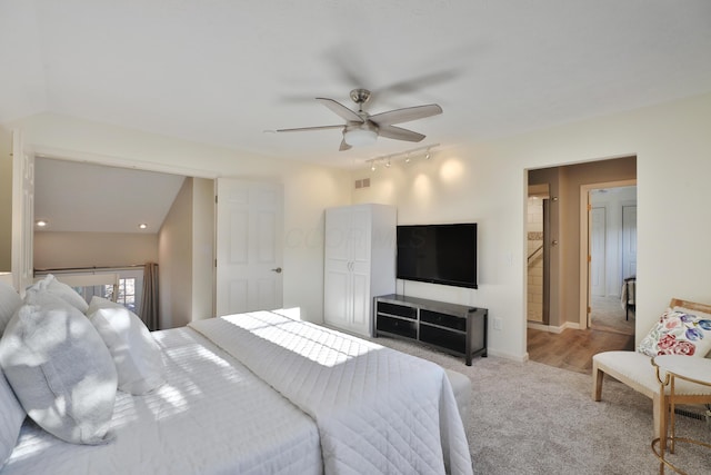 carpeted bedroom with rail lighting and ceiling fan