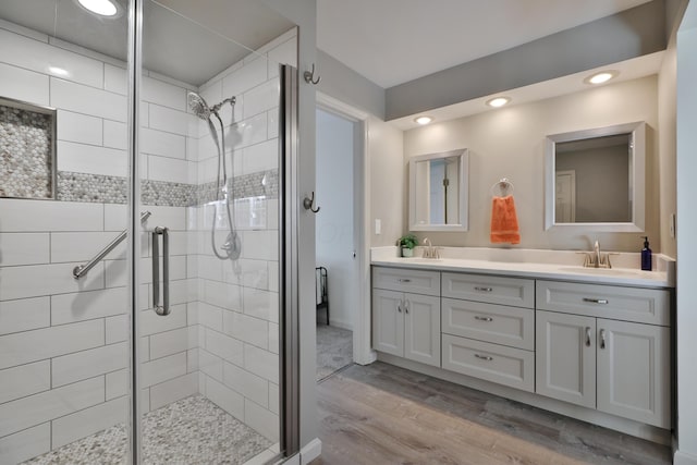 bathroom featuring hardwood / wood-style flooring, vanity, and walk in shower