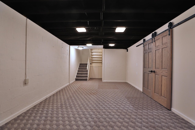 basement with carpet floors and a barn door