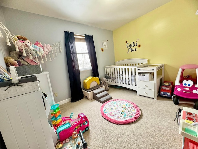 carpeted bedroom featuring a nursery area