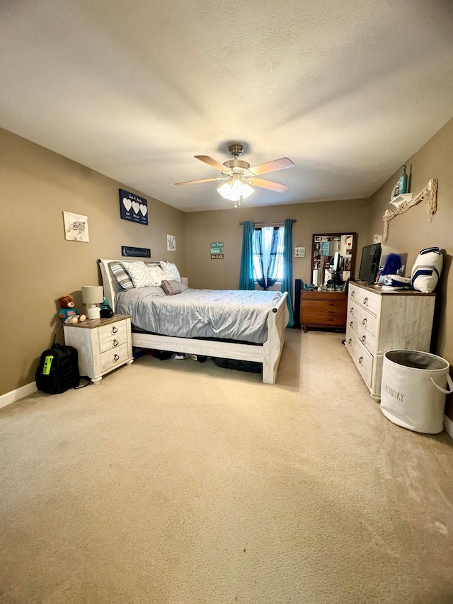 bedroom featuring light carpet, ceiling fan, and a textured ceiling