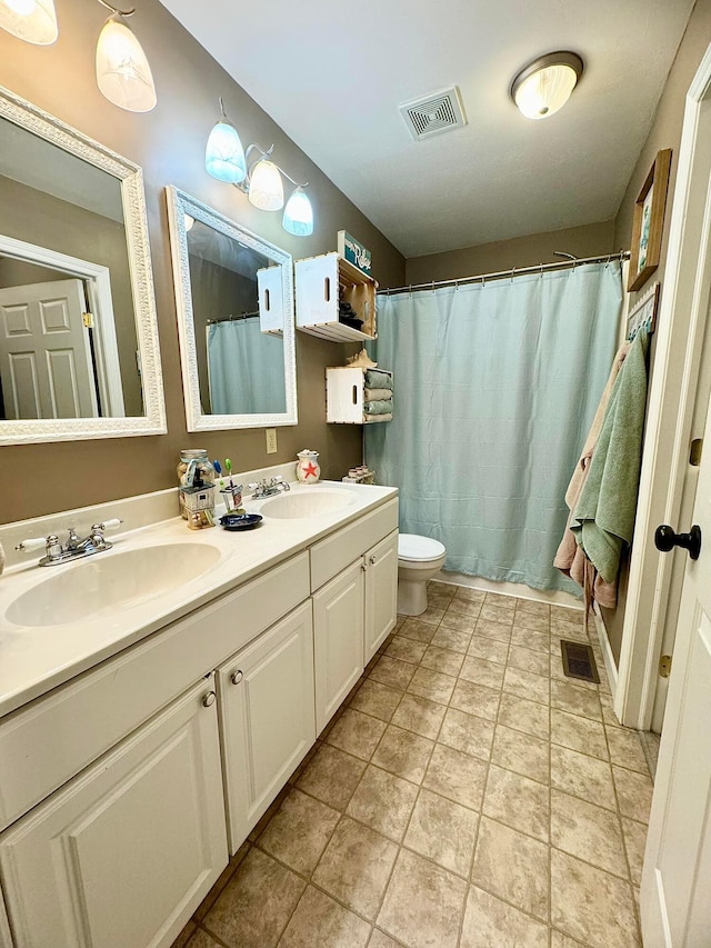 bathroom with toilet, tile patterned flooring, and vanity