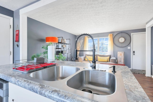 kitchen with sink, dark wood-type flooring, and a textured ceiling