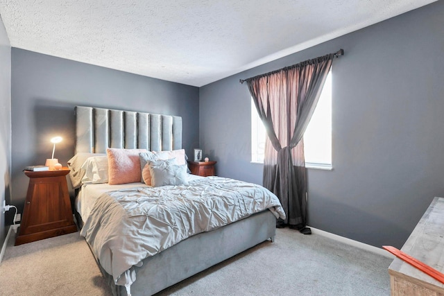 bedroom featuring a textured ceiling and light colored carpet