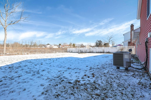 yard layered in snow featuring central AC unit