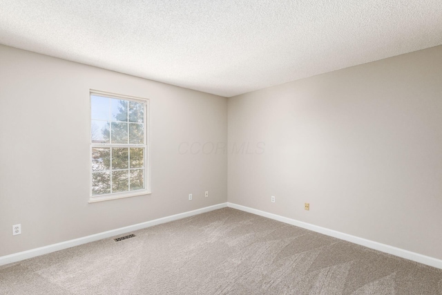 carpeted spare room featuring a textured ceiling