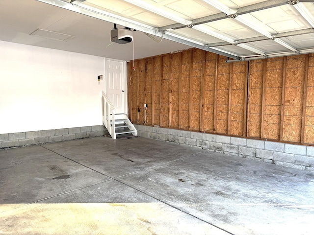 garage featuring a garage door opener and wood walls