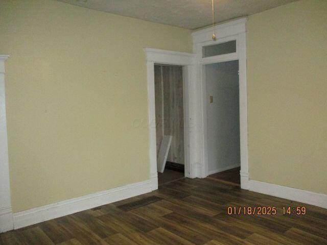 spare room featuring dark wood-type flooring