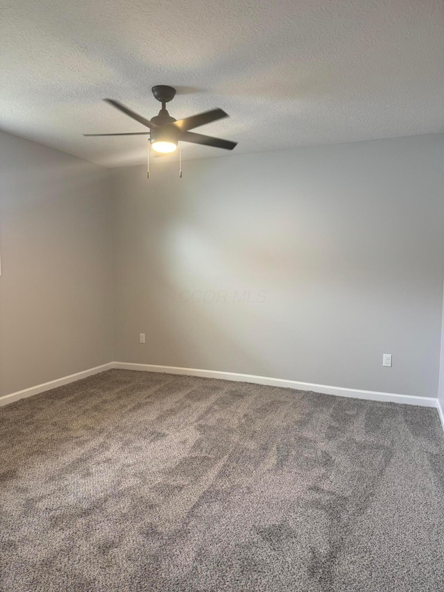 carpeted spare room featuring a textured ceiling and ceiling fan