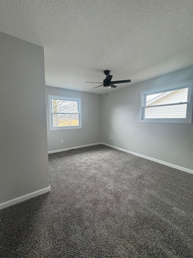 carpeted spare room with a healthy amount of sunlight, a textured ceiling, and ceiling fan