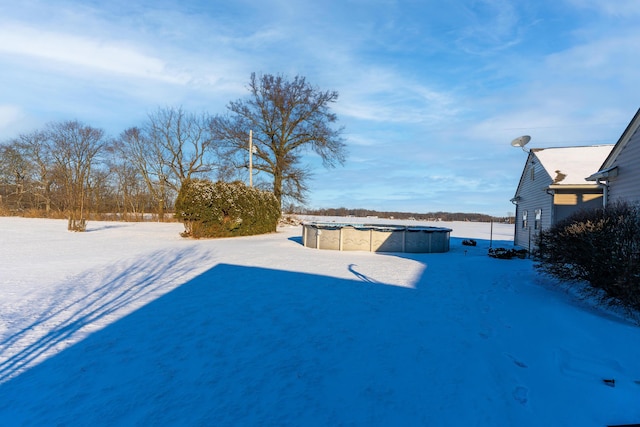 yard layered in snow with a covered pool