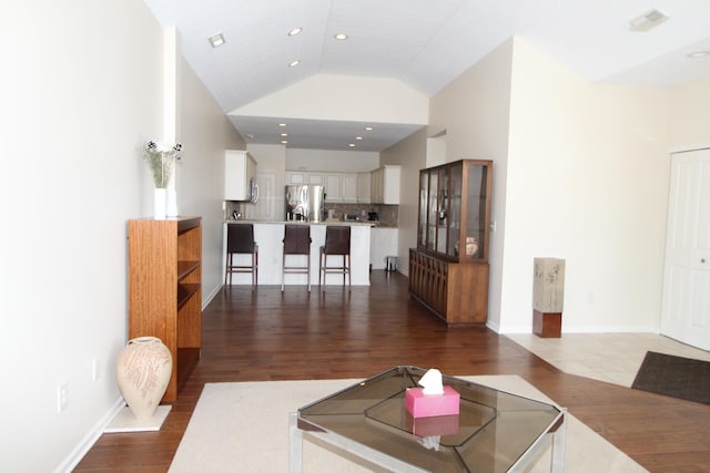 living room featuring lofted ceiling and wood-type flooring