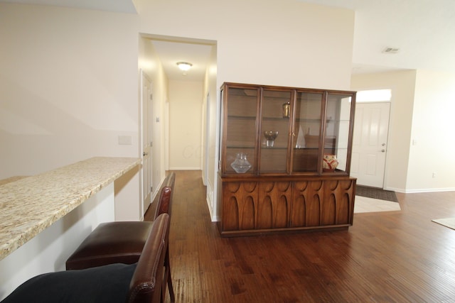 bar with dark wood-type flooring and built in desk