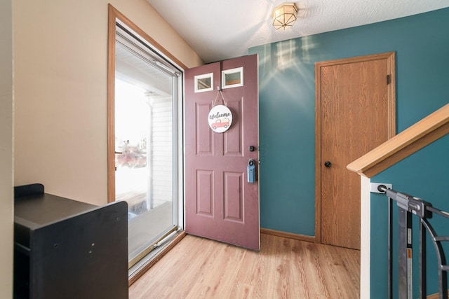 entryway featuring a textured ceiling and light hardwood / wood-style floors