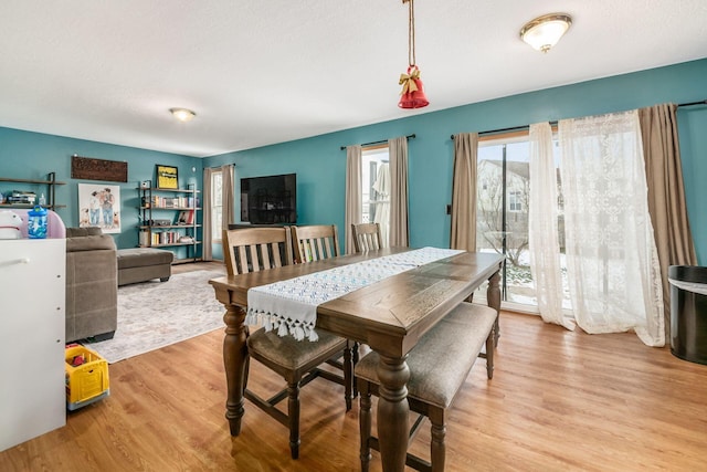 dining space featuring light hardwood / wood-style floors and a textured ceiling