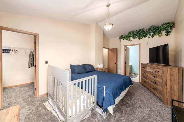 carpeted bedroom with a walk in closet, vaulted ceiling, ensuite bath, and a closet