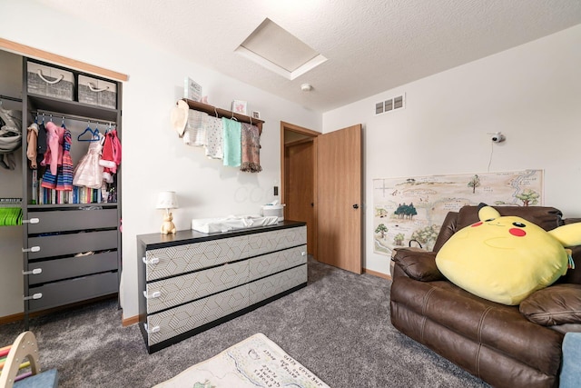 bedroom with a textured ceiling, a closet, and dark colored carpet