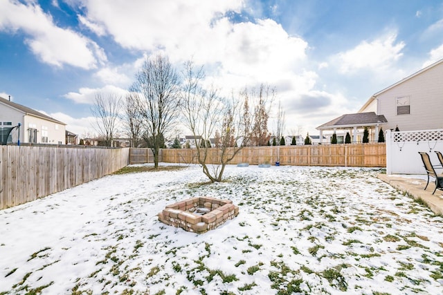 yard layered in snow with an outdoor fire pit