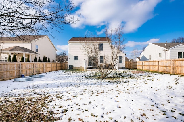 snow covered back of property with central AC