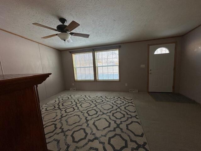 entryway featuring a textured ceiling, ceiling fan, and a healthy amount of sunlight