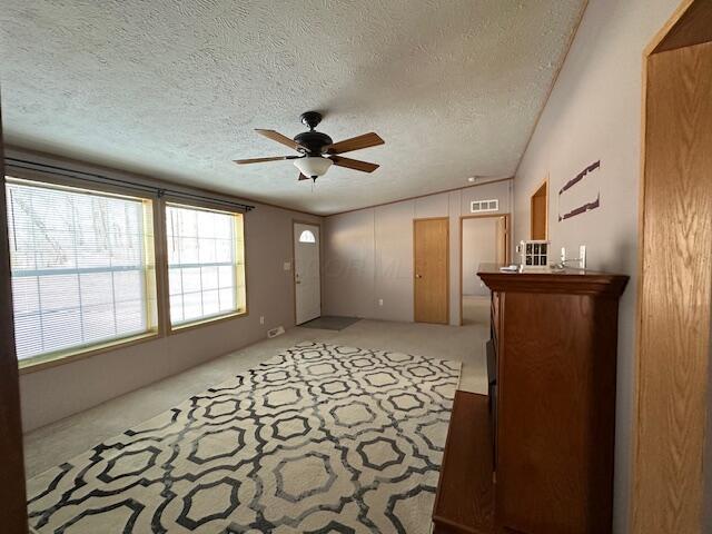 unfurnished room with ceiling fan, a textured ceiling, and vaulted ceiling